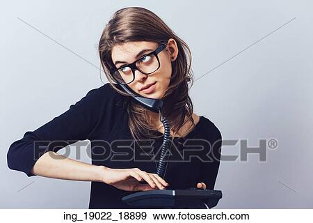 Woman with office or home phone. On a gray background. View Large Photo Image Stock Photo - Woman with office or home phone. On a gray background.. Fotosearch