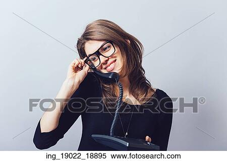 Woman with office or home phone. On a gray background. View Large Photo Image Stock Photography - Woman with office or home phone. On a gray background.. Fotosearch