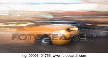 Stock Photograph - Yellow taxi moving on a street, Times Square, Manhattan, New York City, New York State, USA. Fotosearch