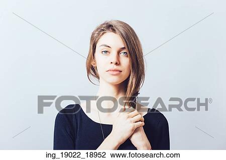 Stock Image - young beautiful girl pulls her long hair hand. Fotosearch