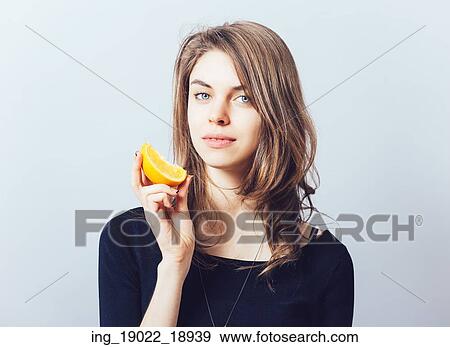 Stock Photo - young beautiful woman with citrus orange fruit having fun. . Fotosearch