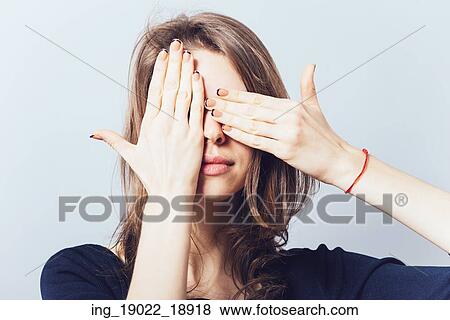 Young teen woman covering her eyes isolated on a gray background View Large Photo Image Stock Photo - Young teen woman covering her eyes isolated on a gray background. Fotosearch