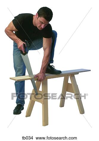 Picture - Photograph of a man sawing through a plank of wood. Fotosearch