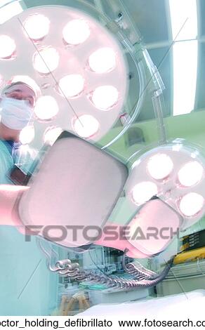 Picture - Doctor holding defibrillato. Fotosearch