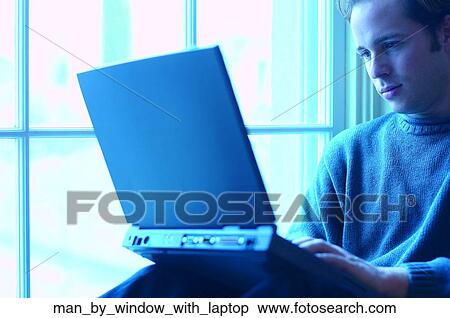 Man by window with laptop View Large Photo Image Stock Photography - Man by window with laptop. Fotosearch