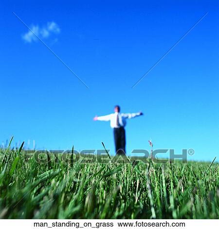Man standing on grass View Large Photo Image Stock Photograph - Man standing on grass. Fotosearch