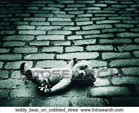 Stock Image - Teddy bear on cobbled stree. Fotosearch