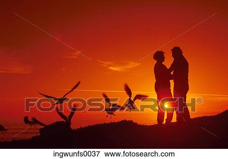 Couple Embracing at Sunset View Large Photo Image Stock Photo - Couple Embracing at Sunset. Fotosearch