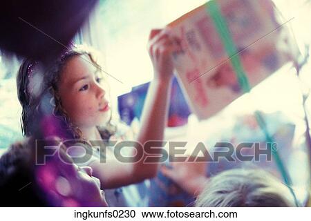 Stock Image - Little Girl Opening Presents. Fotosearch