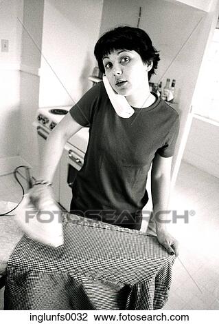 Stock Image - Woman on Phone Ironing. Fotosearch