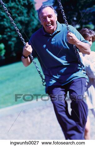 Woman Pushing Man on Swing View Large Photo Image Stock Photo - Woman Pushing Man on Swing. Fotosearch