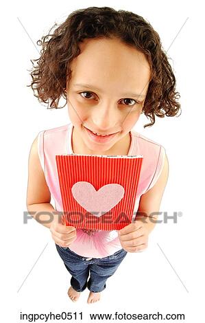 Stock Image - Little girl holding red heart Valentines Day card . Fotosearch