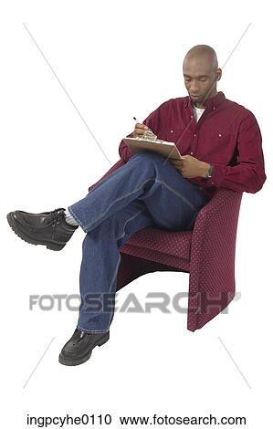 Stock Image - Seated man reading clipboard . Fotosearch