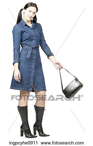 Smiling woman in denim dress with black purse View Large Photo Image Stock Image - Smiling woman in denim dress with black purse. Fotosearch