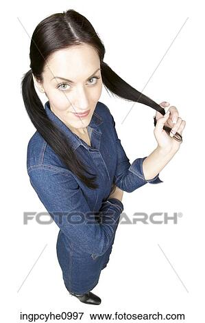 Stock Photo - Smiling woman pulling on her pigtail. Fotosearch