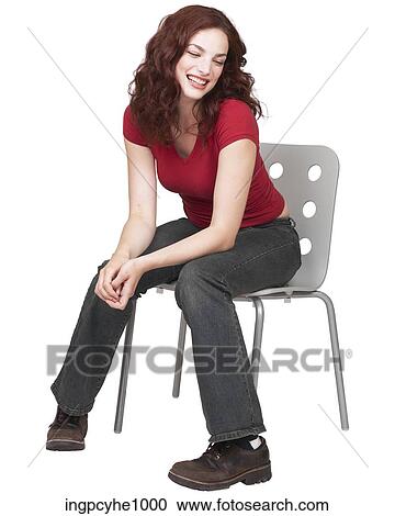 Stock Image - Smiling young brunette sitting on a chair. Fotosearch