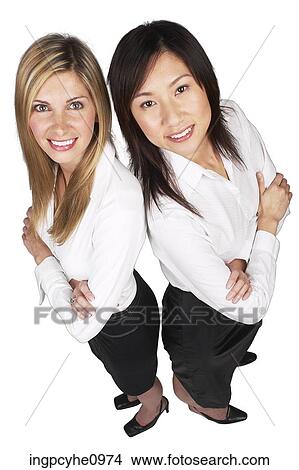 Two young business women standing back to back View Large Photo Image Picture - Two young business women standing back to back. Fotosearch