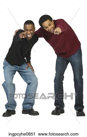 Two young men pointing at an object and laughing View Large Photo Image Stock Image - Two young men pointing at an object and laughing . Fotosearch