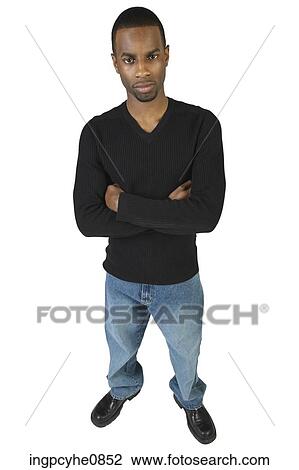 Young man standing with his arms folded View Large Photo Image Stock Image - Young man standing with his arms folded. Fotosearch