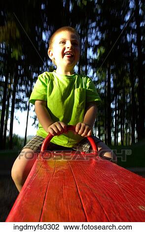 Boy on Red See-Saw View Large Photo Image Stock Image - Boy on Red See-Saw. Fotosearch