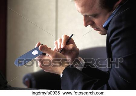 Stock Photography - Businessman Using Cell Phone and PDA. Fotosearch