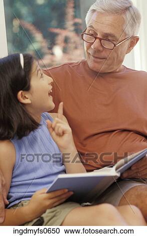 Stock Image - Grandpa Reading with Granddaughter. Fotosearch