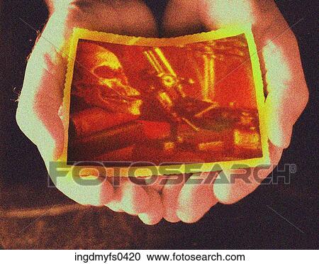 Stock Image - Hands Holding Photograph. Fotosearch