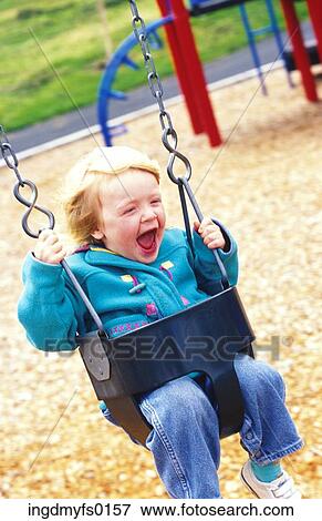 Stock Photo - Laughing Child Swinging at Playground. Fotosearch