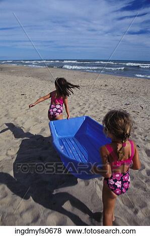 Little Girls Playing With a Boat at the Beach View Large Photo Image Stock Photo - Little Girls Playing With a Boat at the Beach. Fotosearch