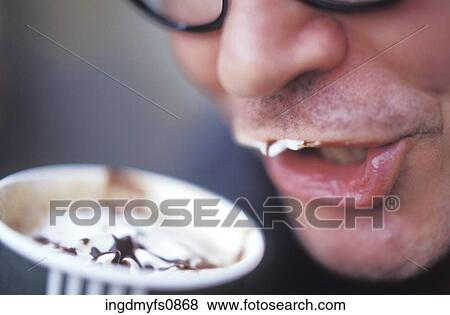 Stock Photo - Man Drinking a Creamy Coffee Drink. Fotosearch
