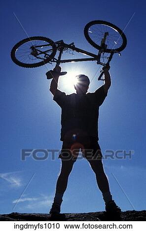 Stock Image - Man Holding Bike Above His Head. Fotosearch