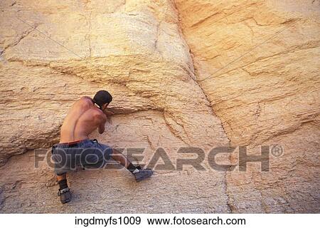 Stock Photo - Man Rock Climbing With No Ropes. Fotosearch