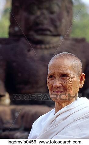 Stock Photograph - Old Person in Front of Religious Statue. Fotosearch