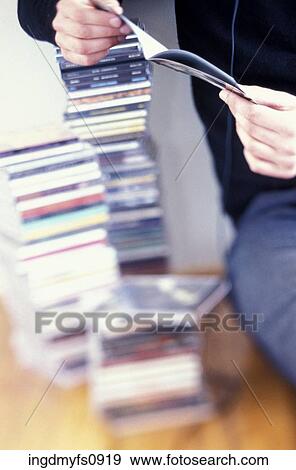 Stock Photo - Person Listening to CD Collection. Fotosearch