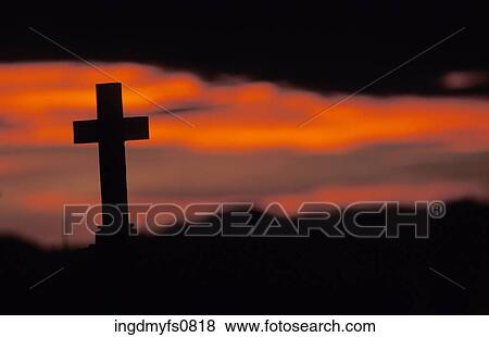 Stock Photo - Sun Setting on Lone Cross in Graveyard. Fotosearch