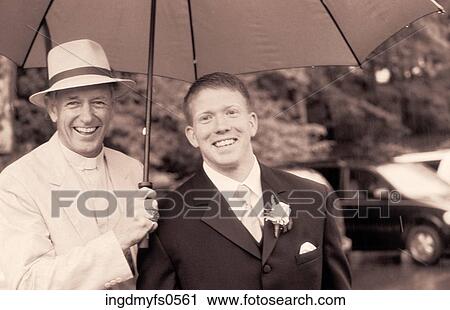 Stock Image - Two Happy Men and an Umbrella. Fotosearch