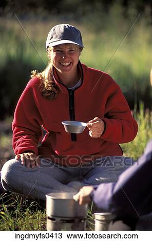 Stock Image - Woman Eating At Camp. Fotosearch