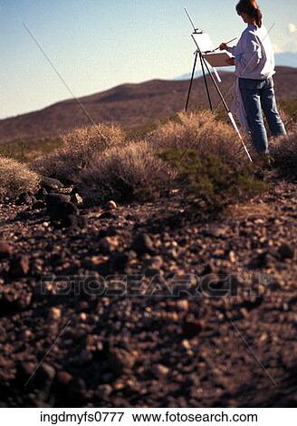 Stock Photo - Woman Painting in Rural Landscape. Fotosearch