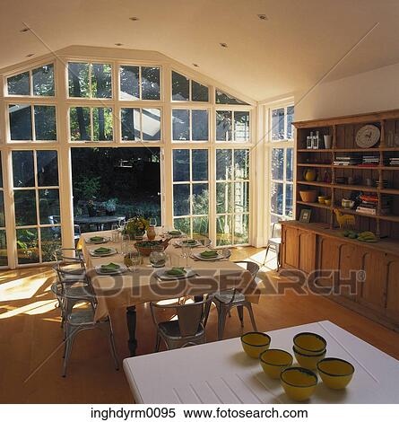 A dining table near a window opening into the garden View Large Photo Image Stock Photography - A dining table near a window opening into the garden. Fotosearch