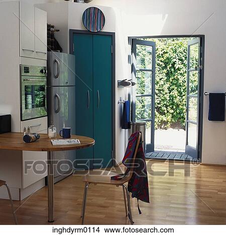 A modern kitchen with a door opening into a garden View Large Photo Image Picture - A modern kitchen with a door opening into a garden. Fotosearch
