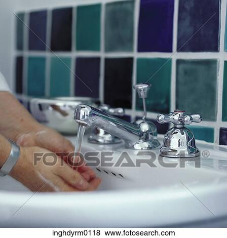 Close-up of a person washing their hands in a wash basin View Large Photo Image Stock Photo - Close-up of a person washing their hands in a wash basin. Fotosearch