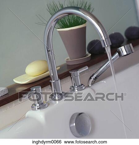 Stock Photograph - Close-up of a running a tap in a sink. Fotosearch