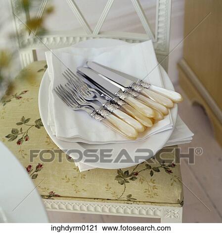Close-up of a set of forks and knives on a white table napkin View Large Photo Image Stock Image - Close-up of a set of forks and knives on a white table napkin. Fotosearch