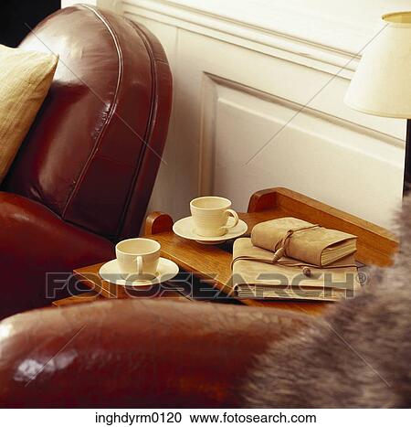 Stock Image - Close-up of tea cups on a side table near a couch. Fotosearch