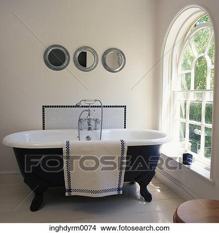 View of a bathtub beside a window View Large Photo Image Picture - View of a bathtub beside a window. Fotosearch