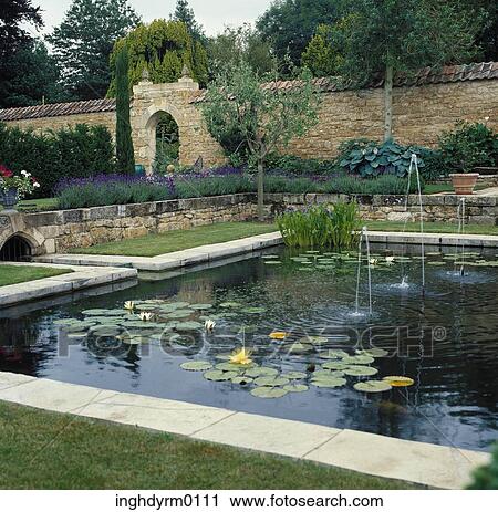 View of an artificial pond with lily pads and fountains in a landscaped garden View Large Photo Image Stock Image - View of an artificial pond with lily pads and fountains in a landscaped garden. Fotosearch