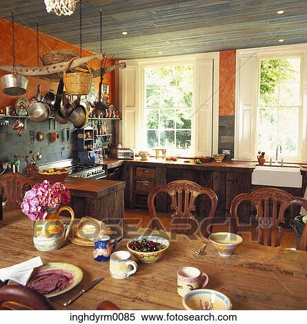 View of pots and pans hung in a kitchen with a dining table View Large Photo Image Stock Photography - View of pots and pans hung in a kitchen with a dining table. Fotosearch
