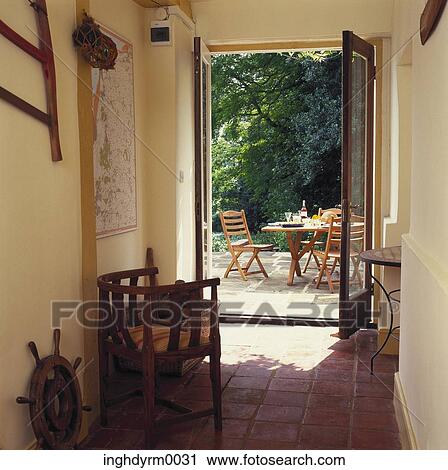Stock Image - View through the door of garden chairs and table on a porch. Fotosearch