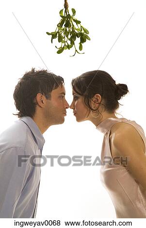 A couple kissing under mistletoe View Large Photo Image Stock Photo - A couple kissing under mistletoe. Fotosearch