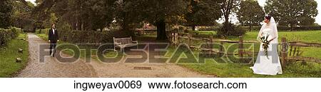 A groom walking towards his bride in a garden View Large Photo Image Stock Photo - A groom walking towards his bride in a garden. Fotosearch